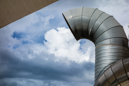 complex aluminium air conditioning piping against the skyの写真素材