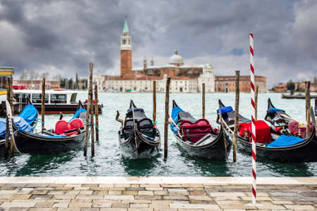 Several Gondolas and Giorgio Maggiore island in Venice.の写真素材