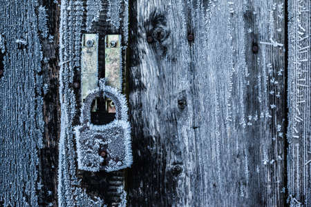 A padlock with ice crystals growing on it in the cold winter
