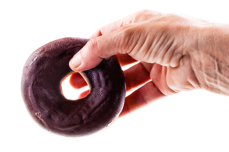 a hand holding a delicious donut isolated over a white backgroundの写真素材