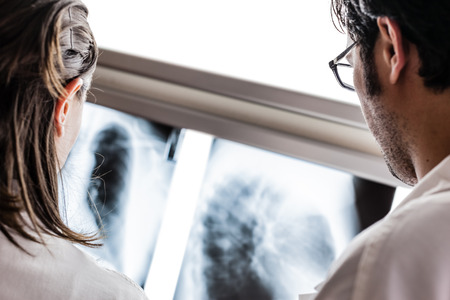 two yound doctors examining a x-ray film at the diaphanoscope