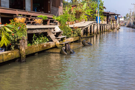 hovels of a small village on the riverside of a canal in the thai countryside in Ratchaburi district, Thailandの写真素材