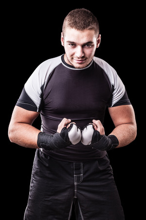 a young kickboxer or boxer isolated over a black backgroundの写真素材