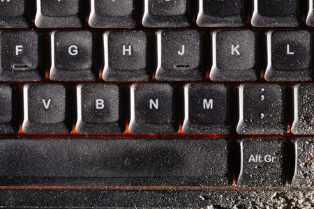 a dirty black keyboard covered in ash or dustの写真素材