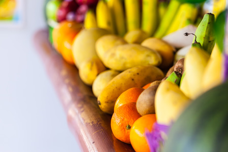 different vivid colored fruits on sale in a thai fruit standの写真素材
