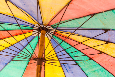 a colorful rainbow colored beach umbrella seen from belowの写真素材