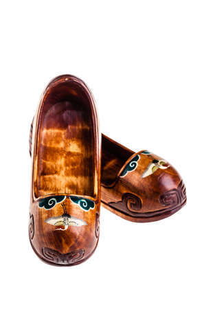 a pair of small korean shoes wooden miniature isolated over a white background