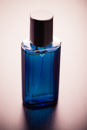 a luxurious blue crystal perfume bottle on a wooden surfaceの写真素材
