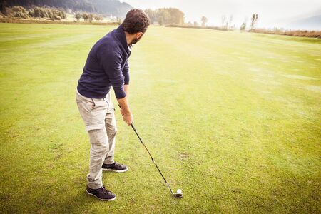 a golf player making a swing on a vibrant beautiful golf courseの写真素材