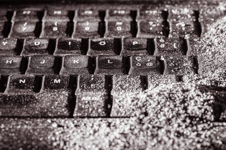 a dirty black keyboard covered in ash or dustの写真素材