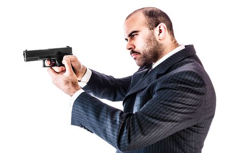 portrait of a classy businessman or mobster or security guard holding a gun isolated over a white backgroundの写真素材