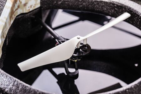 detail shot of a small camouflaged quad copter spy drone over a black reflective surfaceの写真素材