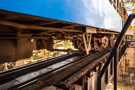 a passenger train crossing the famous bridge on the river Kwai, in Thailandの写真素材