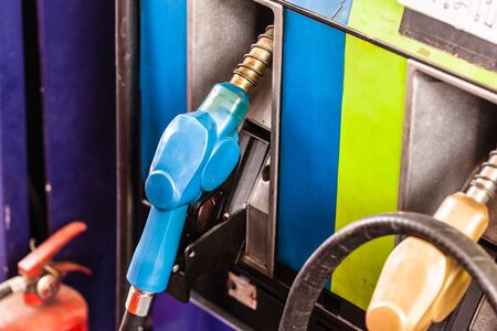 colored petrol gas pump nozzles in a service stationの写真素材