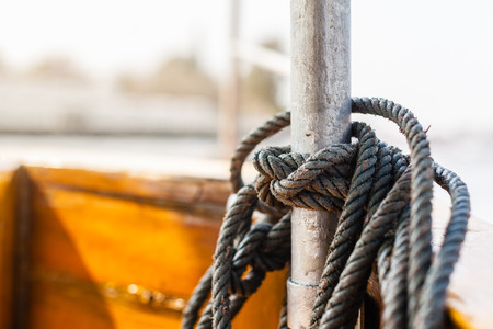 detail shot of a nautical knotted treaded rope on an old boatの写真素材
