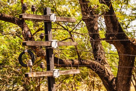 a small old telegraph pole with wires in the countryside