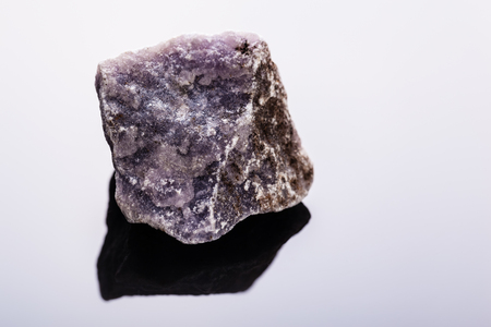 close up shot of a fragment of lepidolite mineral on a dark surface