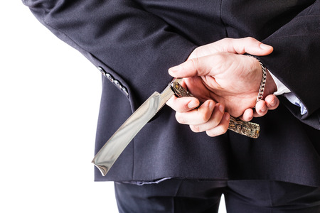 a young and handsome businessman holding a cut-throat razor isolated over a white backgroundの写真素材