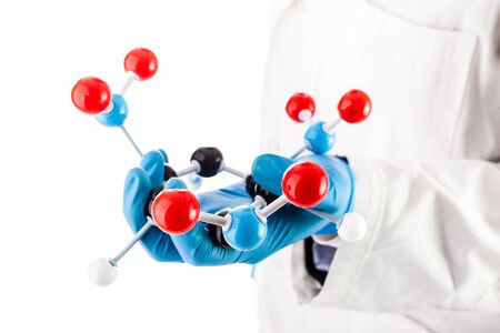 a doctor or researcher with a white lab coat holding a trinitrotoluene tnt molecular model isolated over whiteの写真素材