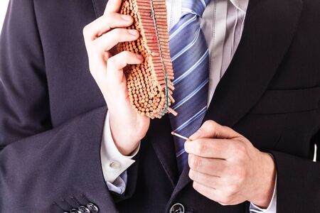 a young and handsome businessman lighting a chain firecrackerの写真素材