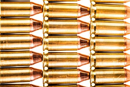a lot of 9mm handgun bullets geometrically placed in rows isolated over a white background