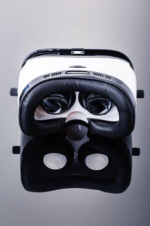 a pair of virtual reality glasses to be used with smartphones over a dark shiny surfaceの写真素材