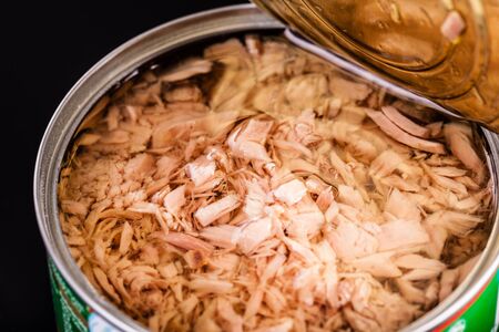 macro shot of an opened tuna tin can on a dark background