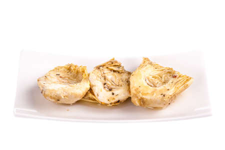 a cup of Preserved Artichokes hearts with herbs isolated ovaer a white backgroundの写真素材