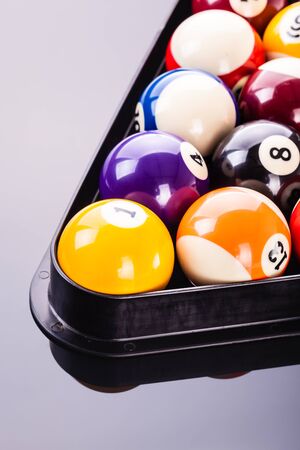 some pool balls in the triangle shot over a dark reflective surface
