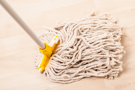 a spaghetti mop head cleaning a light wooden floorの写真素材