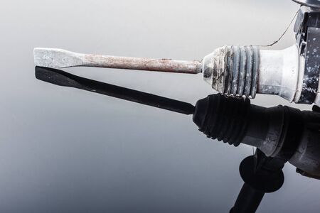a dirty professional demolisher rotary hammer drill over a dark reflective surfaceの写真素材