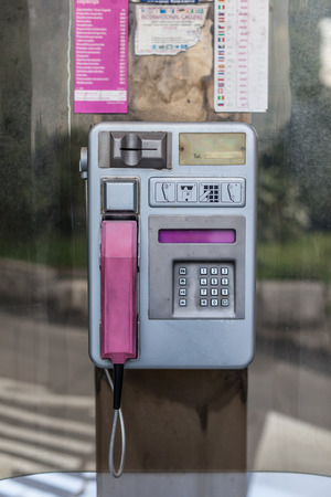 an old phone booth in croatia, with aluminium dial and pink receiverの写真素材
