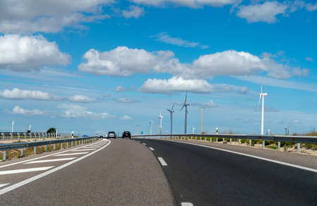 View of Wind Turbine Next to Spanish Highway With Cloudy Skiesの写真素材