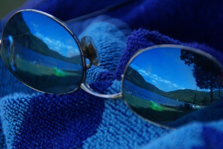 lake, reflected in sunglasses on blue bath towelの写真素材