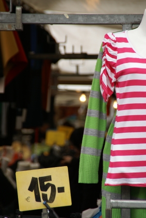 offer in a market stall  a ladies shirt in pink and whiteの写真素材