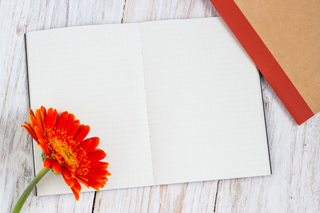 orange colorful gerbera flowers and blank card on the wooden tableの写真素材