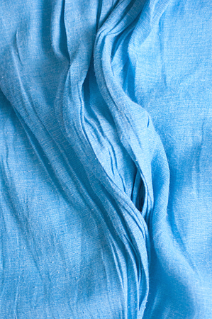 Blue fabric texture with wrinkles and ripples.の写真素材