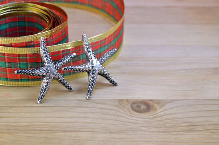 Decorative ribbon and stars as christmas decoration on wooden backgroundの写真素材
