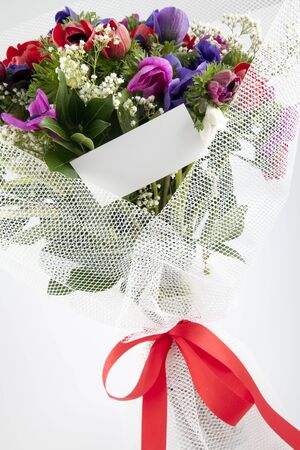 Beautiful bouquet of flowers with blank white card to put your message.の写真素材