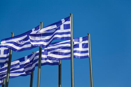White-blue greek flags on clear blue skyの写真素材