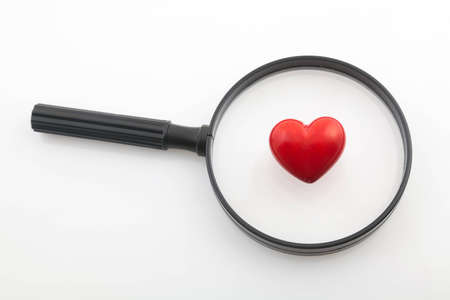 Looking a red heart through a magnifying glassの写真素材