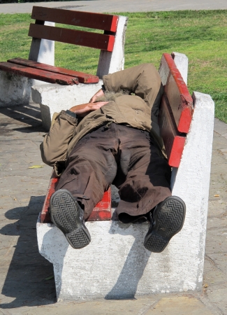 THESSALONIKI, GREECE - MARCH 29: Sleeping homeless man on the bench in a public park on March 29, 2012 in Thessaloniki, Greece. Increase of 25% of the homeless in years 2009-2011 in Greeceのeditorial素材