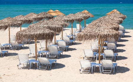 Beautiful beach with deck chairs and umbrellas on the sandy beach in Nea Irakleia  Halkidiki   Thessaloniki - Greeceの写真素材