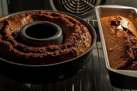 Two chocolate cakes still baking in the ovenの写真素材