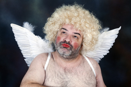 Fat bearded mature hairy cupid with bow and heart arrow.の写真素材