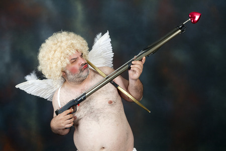 Fat bearded mature hairy cupid with bow and heart arrow.の写真素材