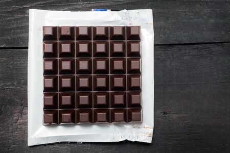 Dark chocolate bar in opened foil wrappingの写真素材