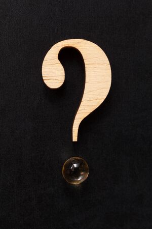 Question mark formed of wood and a pill