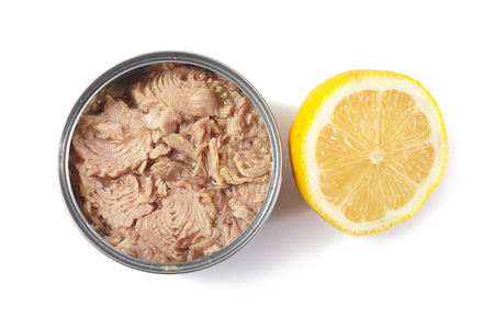 Open tuna tin with half lemon on a white backgroundの写真素材