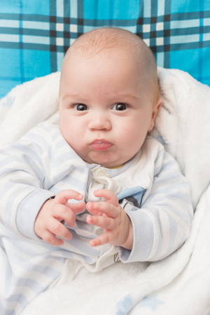 Portrait of a cute baby boy sitting on a pillow. Adorable seven month old happy child.の写真素材